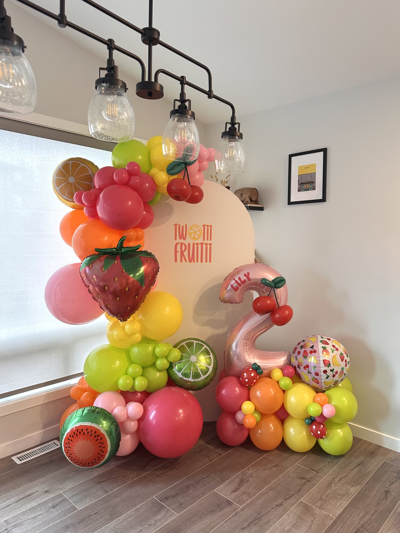 Fruit-themed balloon garland with watermelon, strawberry and citrus balloons for a Tutti Frutti second birthday in Winnipeg