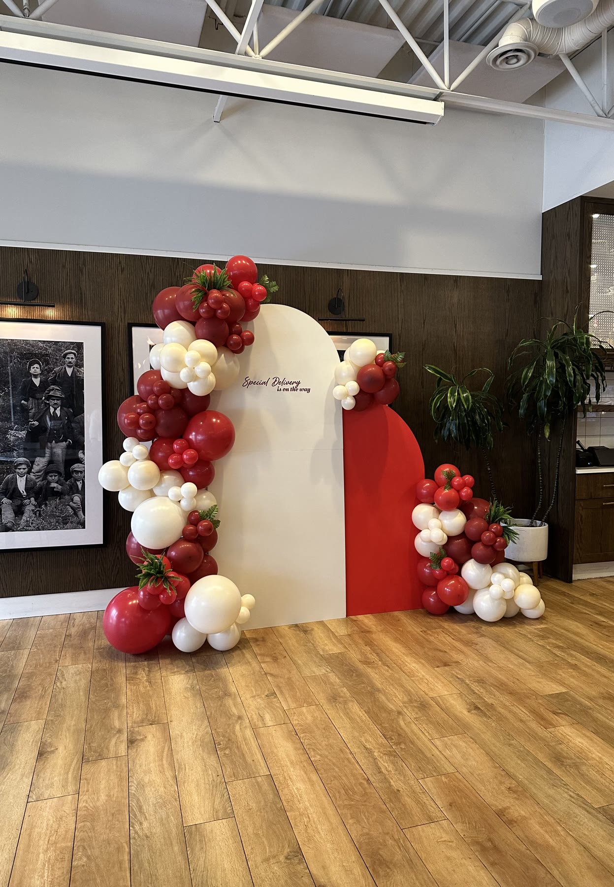 Strawberry-themed red, white and green balloon garland on an arched backdrop in Winnipeg