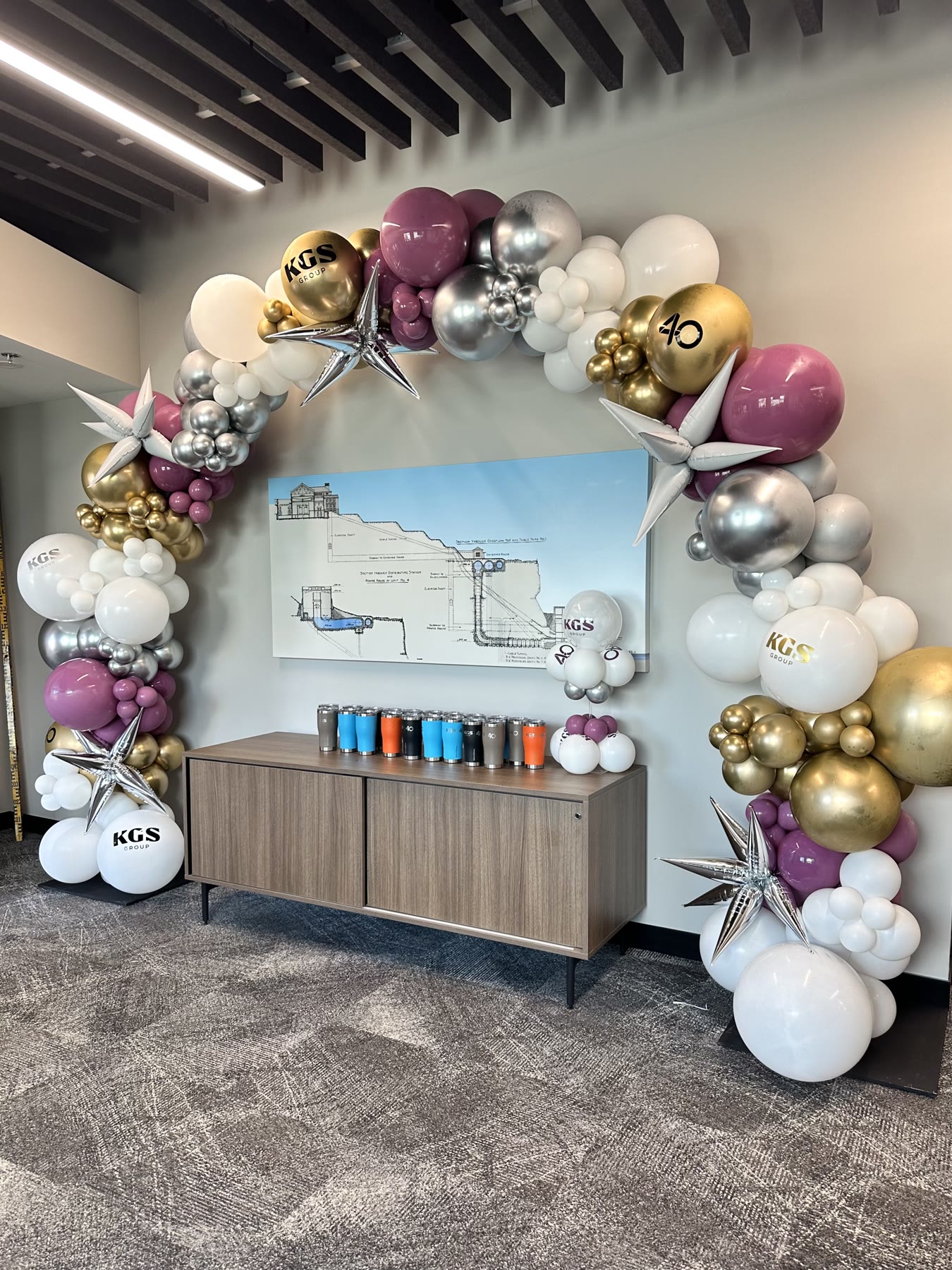 Corporate anniversary balloon arch with printed logo balloons in a Winnipeg office reception