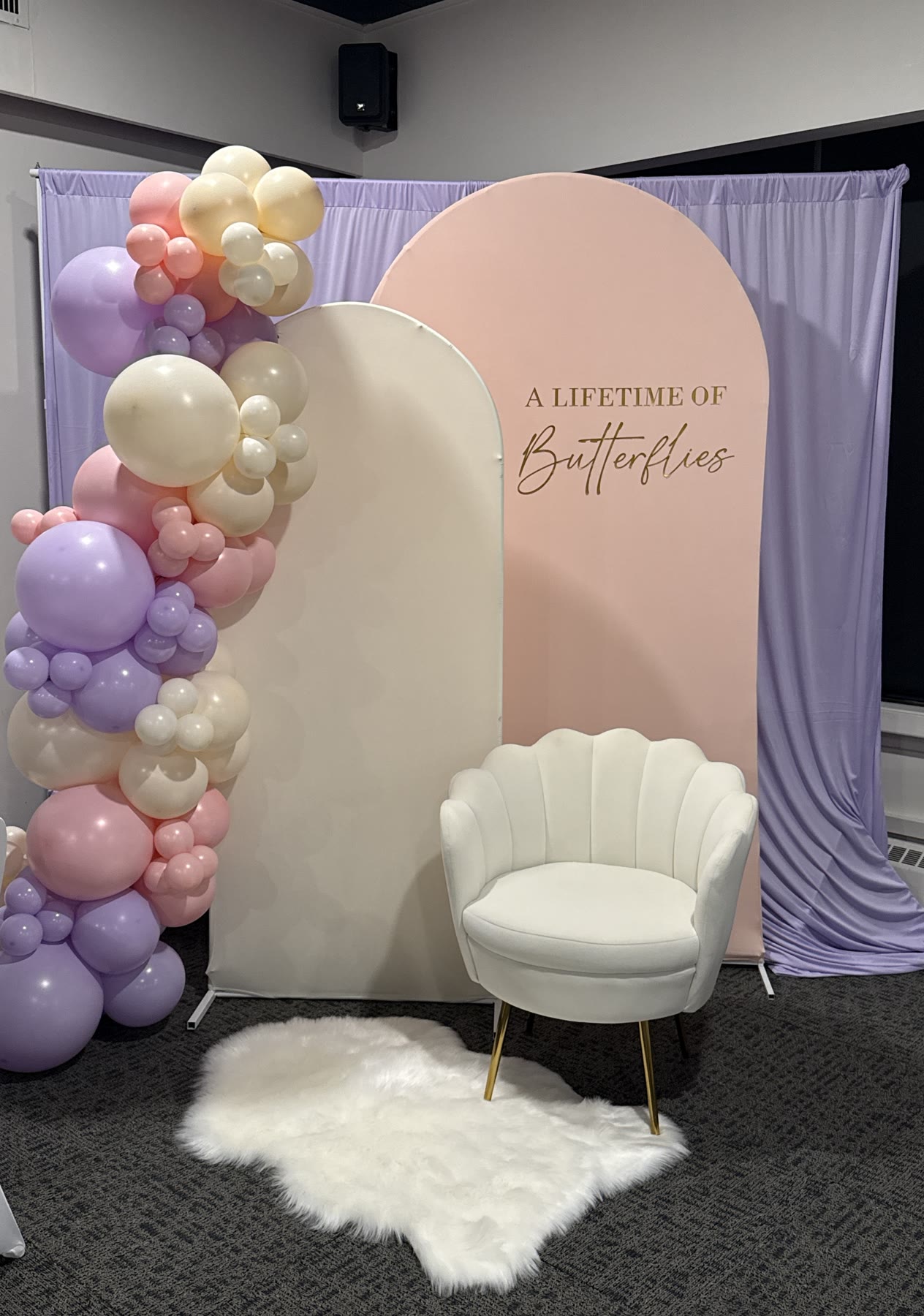 Lilac, blush and cream balloon garland with arched backdrop panels and a shell chair, Winnipeg